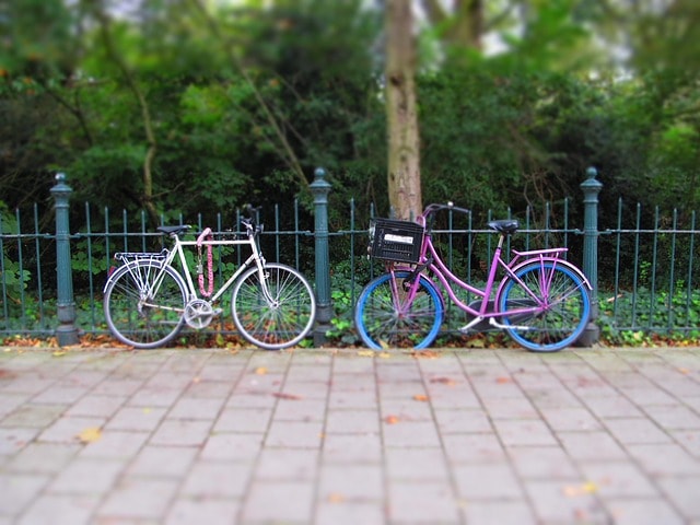 Deux vélos posés sur une rambarde près d'un parc à Amsterdam