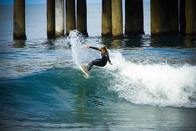 Surfeuse surfant sur les vagues de la plage Manhattan à Los Angeles