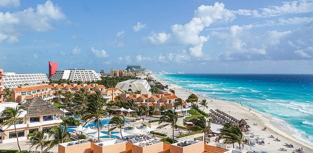 Hotel complexes with swimming pools located on the edge of the beach in Cancun.