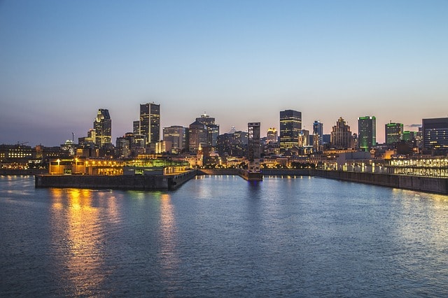 Le fleuve de Saint-Laurent en soirée et la ville de Montréal éclairée en soirée.