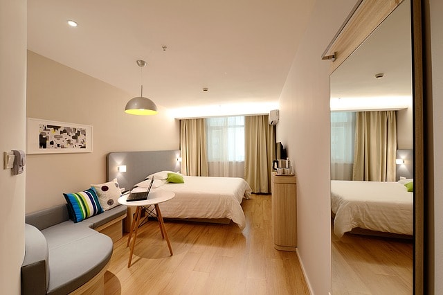 Chambre d'hôtel éclairée et confortable avec lit, canapé et table à Cancun.