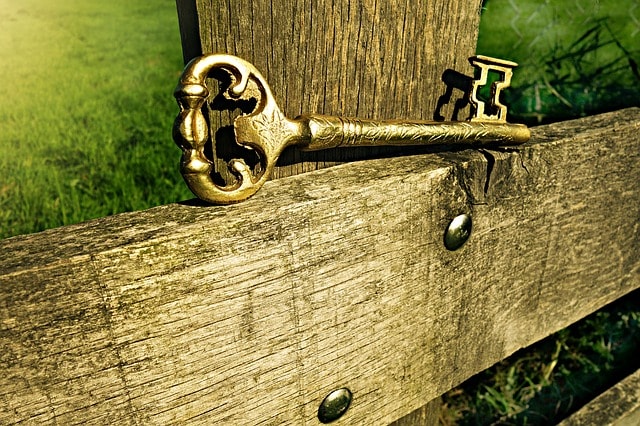 Une cléf dorée placée sur une clôture.