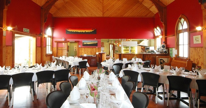 Intérieur de l'église-restaurant à Hahe avec des tables dressées et chaise à Nouvelle Zélande.