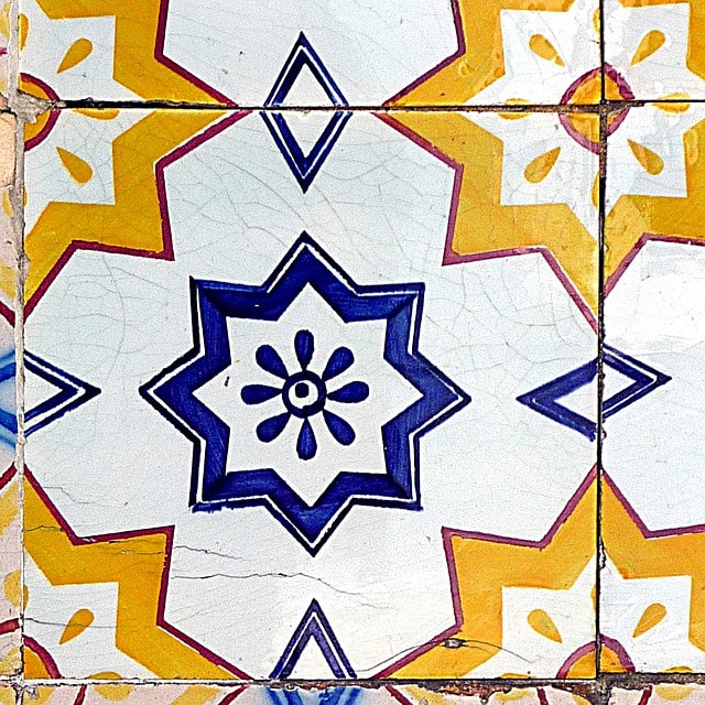 Pièce en céramique présentant des motifs géométriques orange et bleu.