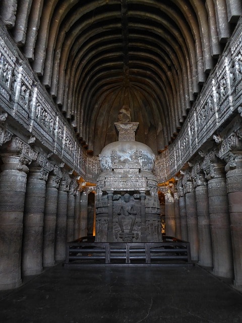 Temple orné de colonnes et sculptures dans une grotte en Inde.