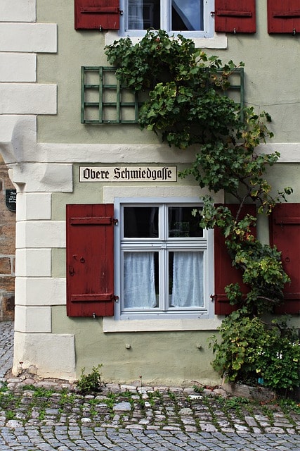 Façade d'une jolie maison avec volets rouges ornée de plantes grimpantes à Copenhague.