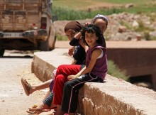 Trois enfants souriants dans une rue vers Marrakech.