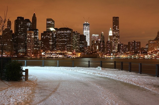 Vue sur le Skyline de New York illuminé et route enneigée.
