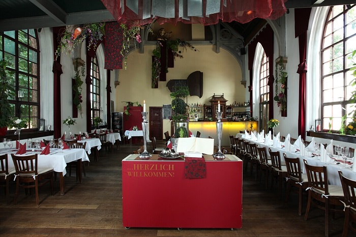 Die Kirche, intérieur de l'église-restaurant avec des tables élégantes et de larges fenêtres.