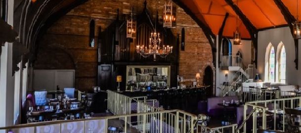 Intérieur de l'église-restaurant Revival House sobre éclairé par un lustre.