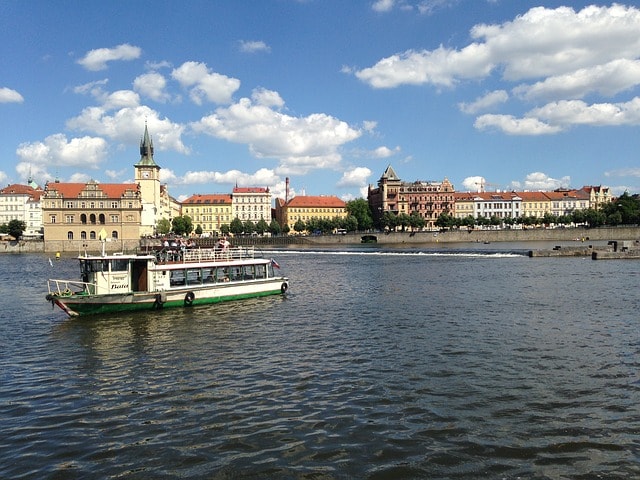 Bateau circulant sur le Vltava et au fond, ville de Prague.