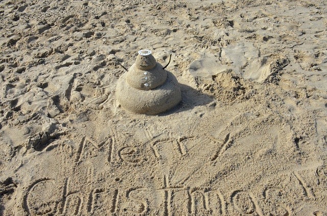 Bonhomme de sable et inscription Merry Christmas dans le sable sur une plage de Miami.