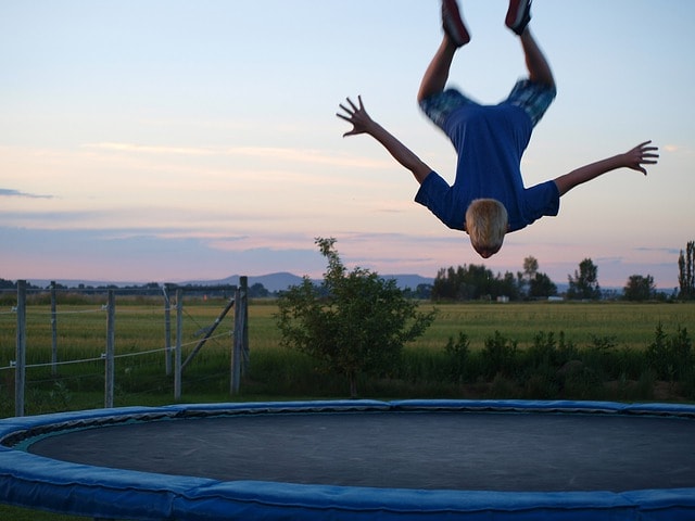 Homme effectuant des sauts acrobatiques sur un trampoline.