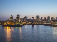 La ville éclairée de Montréal au bord de l'eau en soirée.