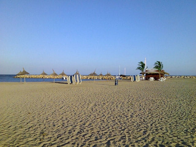Plage de sable fin avec parasols et petite cabane à Costa Dorada.