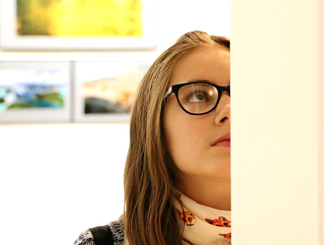 Jeune fille à lunettes admirant un tableau au musée d'art de Singapour.