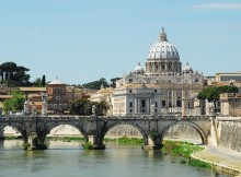 Vue sur la ville de Rome et ses bâtiments, un pont et la rivière.