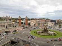 Un grand rond-point avec statue et fontaine à Barcelone.