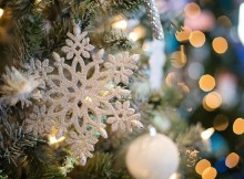 Sapin joliment décoré avec un flocon de neige et des boules.