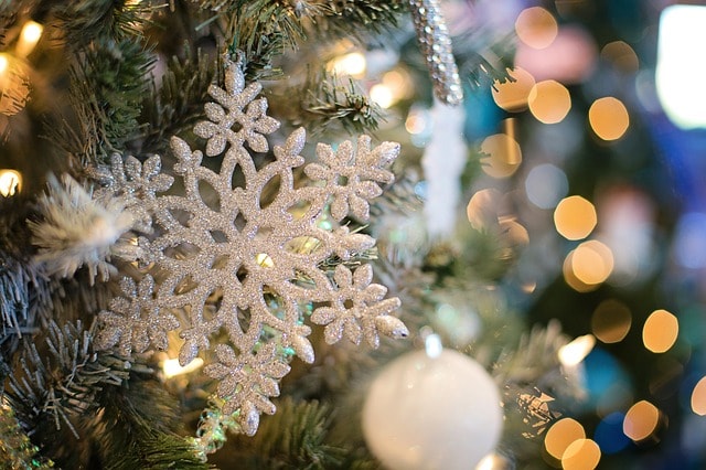 Sapin joliment décoré avec un flocon de neige et des boules.