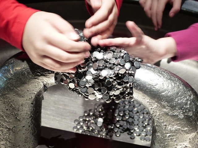 Mains d'enfants effectuant une expérience scientifique dans un musée.