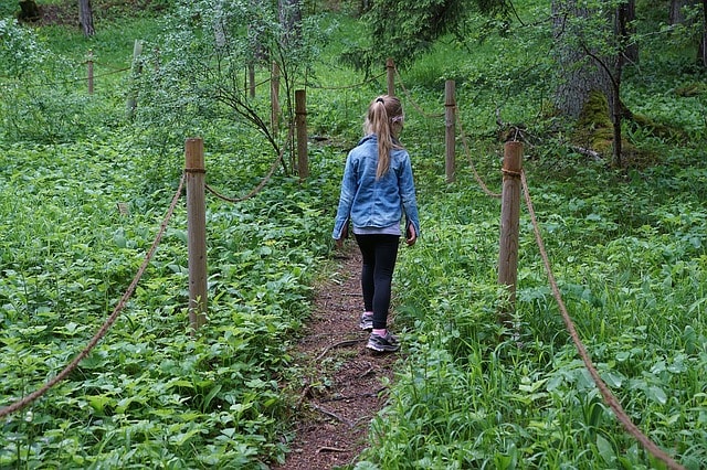 Petite fille suivant un sentier de randonnée.