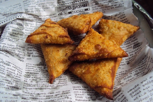 5 samosa sur du papier journal.