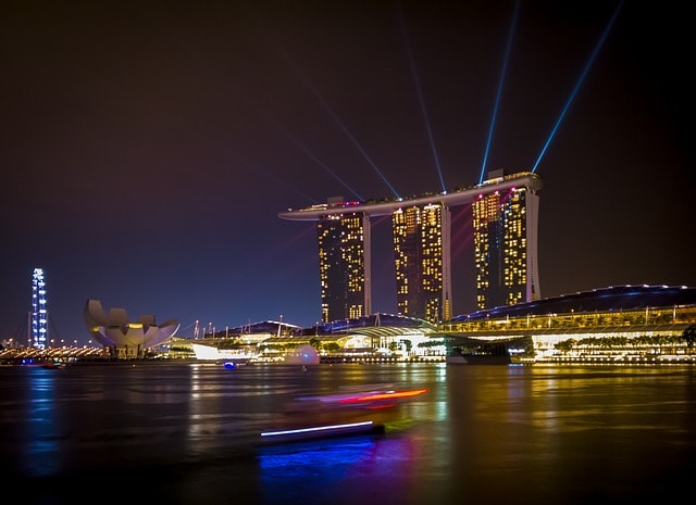 Marina Bay Sands et ses lumières se reflétant sur le fleuve la nuit.
