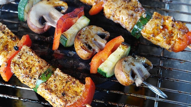 Brochettes de viande, champignons et légume sur un barbecue.