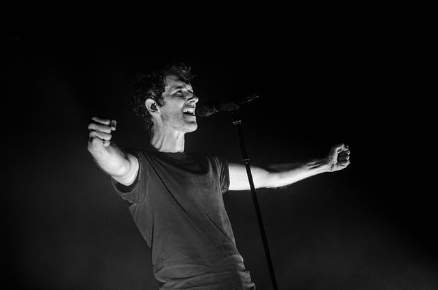 Chanteur en plein spectacle sur scène en noir et blanc.