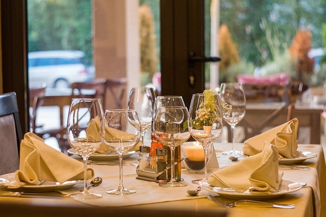 Table dressé avec assiette et verres à pied dans un restaurant.