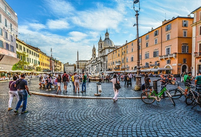 Place pavée piétonne animée à Rome.