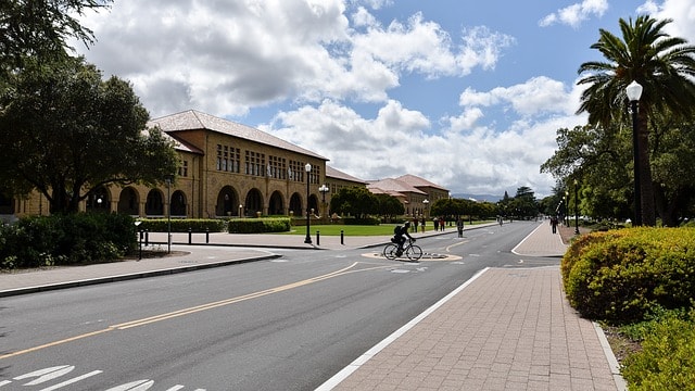Rue dans le campus de l'Université de Stanford bordé par des bâtiments style colonial.