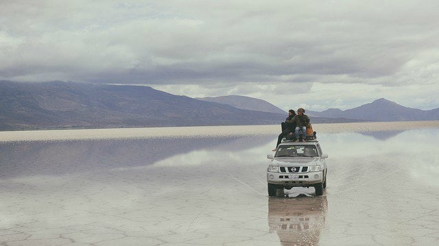 Deux amis et leur 4x4 au beau milieu du désert de Salaar d'Uyuni, en Bolivie