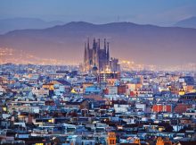 Plongée sur la ville de Barcelone avec la Sagrada Familia en fond au loin.