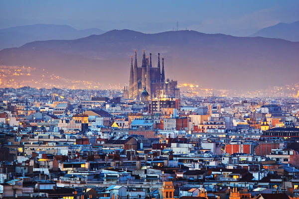 Plongée sur la ville de Barcelone avec la Sagrada Familia en fond au loin.