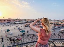 Une femme prenant en photo la jolie place Jamaa El Fna à Marrakech.
