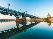 Le pont Saint-Pierre de Toulouse qui se réfléchit dans l'eau bleu.