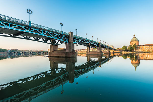 Le pont Saint-Pierre de Toulouse qui se réfléchit dans l'eau bleu.