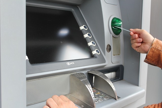 Un homme s'apprête à retirer de l'argent à un distributeur automatique