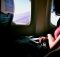 Une personne installée confortablement en avion avec une couverture.