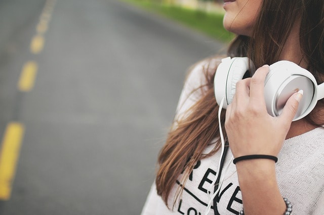 Jeune fille qui porte un casque audio pour se divertir en avion. 