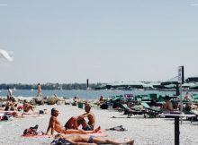 Des gens en voyage dans un pays chaud en train de bronzer sur la plage.