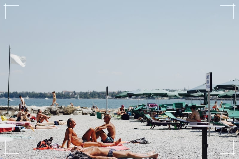 Des gens en voyage dans un pays chaud en train de bronzer sur la plage.
