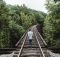 Un homme marchant seul sur les rails d'un train.