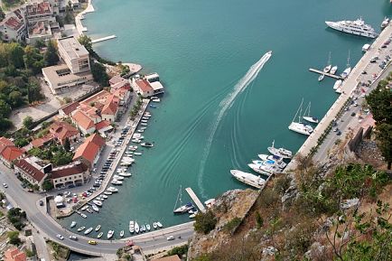 Sortez du port en bateau sur une mer d'eau verte avec un billet d'avion pour le Monténégro.