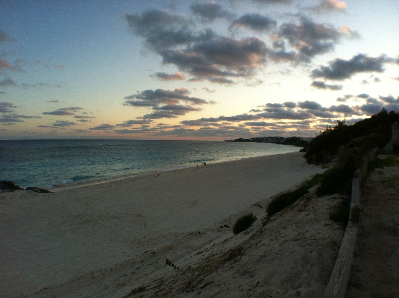 Un vol Bermudes pas cher avec Algofly illustré par une plage de sable blanc sur un coucher de soleil.