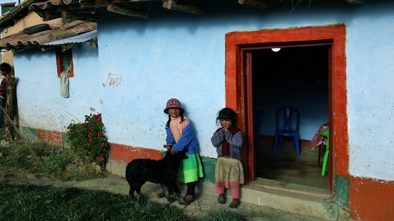 Un vol Bolivie pas cher avec Algofly illustré par deux enfant devant leur maison typique.