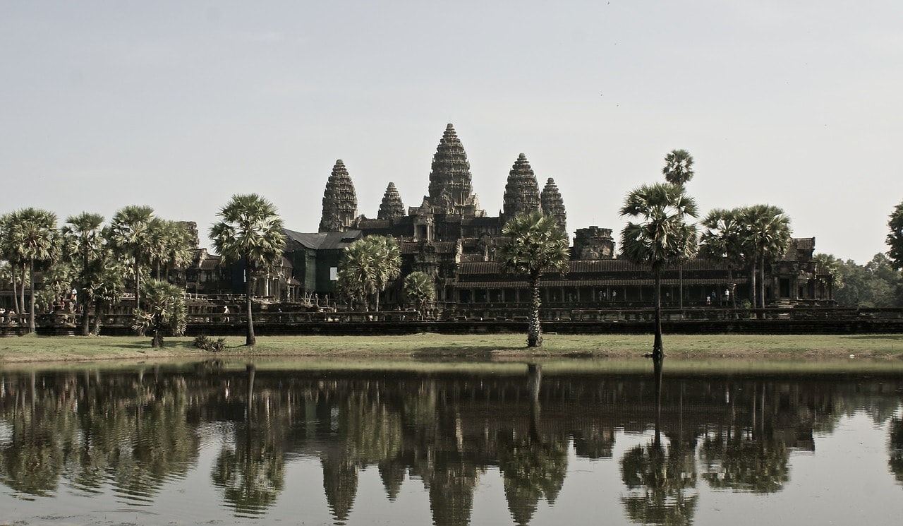 Un vol Cambodge pas cher avec Algofly illustré par un magnifique temple surplombant un lac vert foncé.