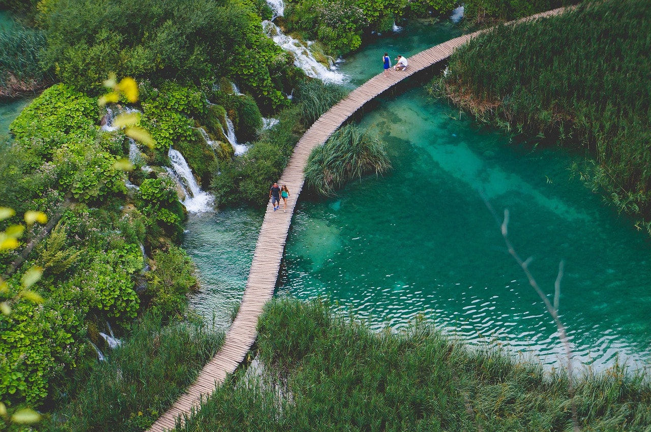 Un vol Croatie pas cher avec Algofly illustré par un chemin de bois surplombant un lac de Plitvice.